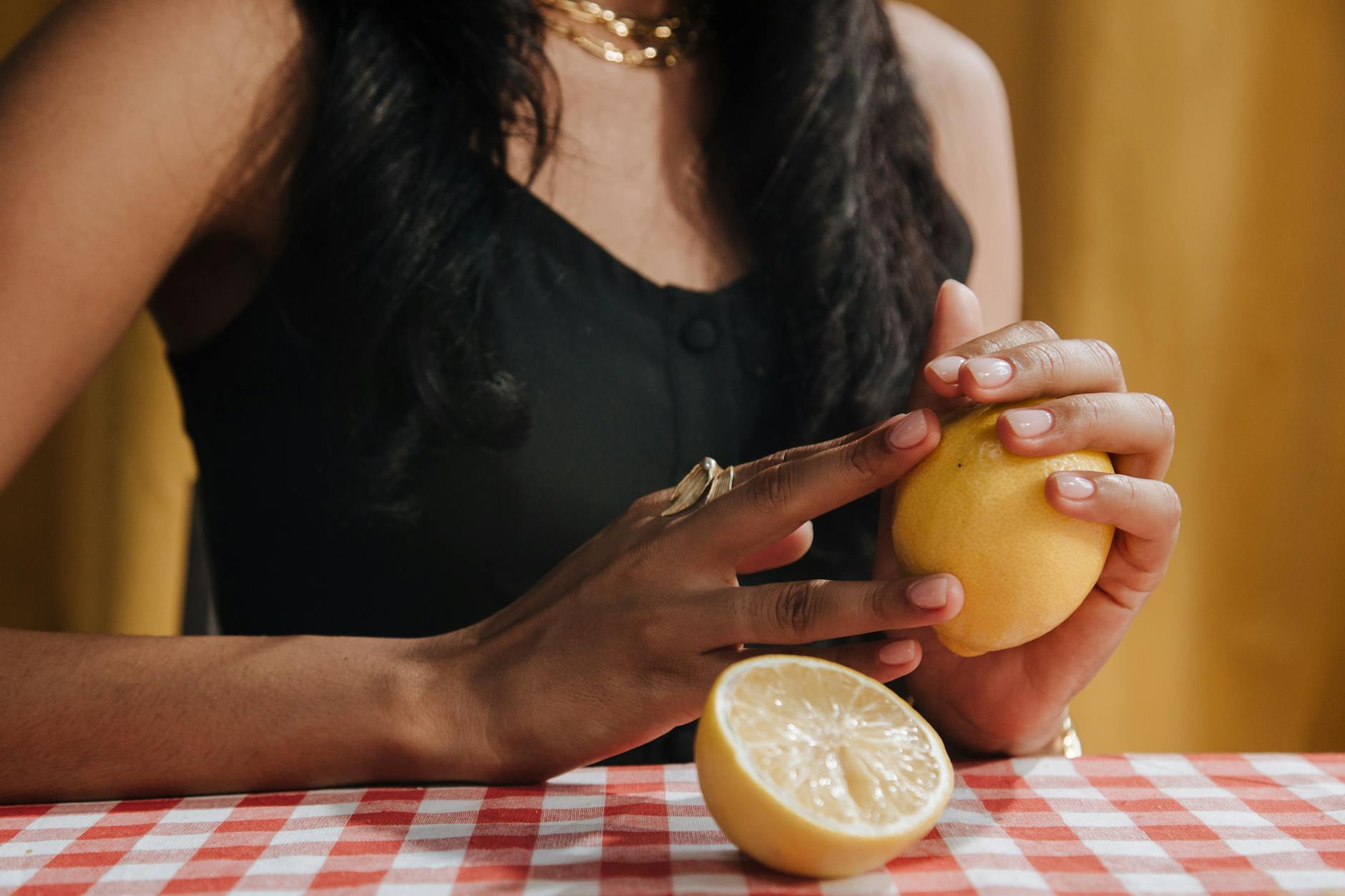 Woman holding a lemon clitoral vibrator in contemplative moment