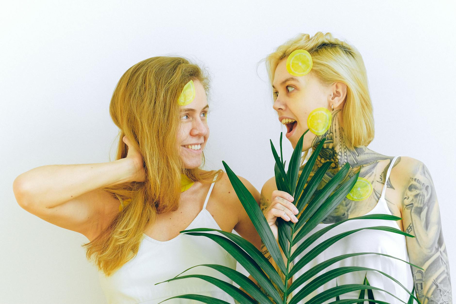 Two smiling women embracing joyfully indoors, expressing intimacy and connection.
