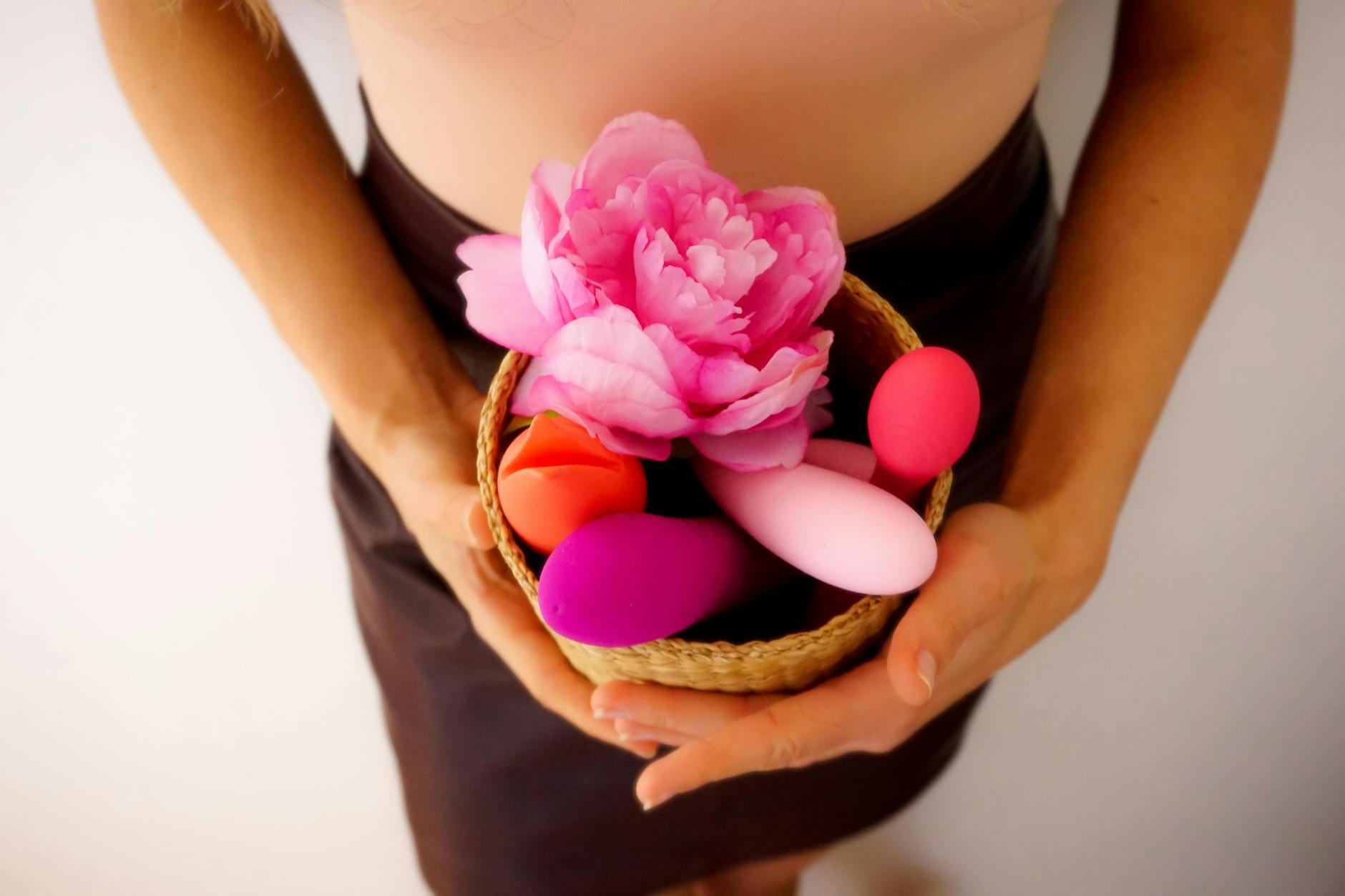 A collection of vibrators and wellness items arranged in a natural basket setting